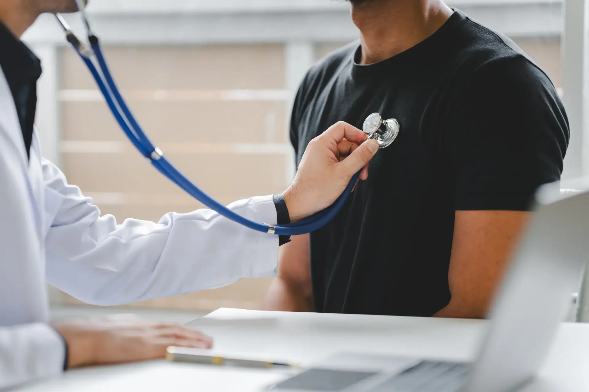 Palpitations cardiaques quand s'inquiéter : cardiologue auscultant un patient lors d'un bilan cardiaque